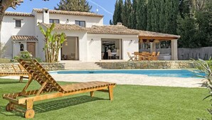 Ein Haus mit Swimmingpool, einer Terrasse mit Tisch und Stühlen sowie einem Holzdeck.