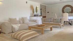 Ein Wohnzimmer mit einer Couch, einem Couchtisch und einem Essbereich mit Stuhl und Tisch.