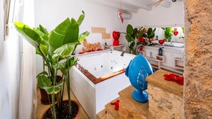 Ein modernes Badezimmer mit Badewanne, Topfpflanzen und einem dekorativen Spiegel.