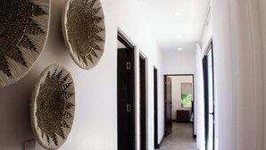Un couloir au design moderne, avec un sol et des murs aux couleurs claires, et une série de portes donnant accès à différentes pièces.