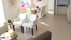 A modern living room with a dining area, a kitchen, and a large window. - Alkmaar Cozy Dutch Villa (West-Graftdijk)