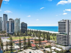 Eine Küstenstadt mit Hochhäusern, einem Strand und einer Mischung aus Wohn- und Geschäftshäusern.