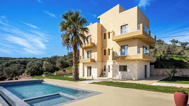A multi-story building with a pool, surrounded by greenery and hills. - Beautiful apartment for the whole family with view at the beach (Stalos)
