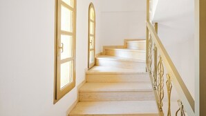 A staircase with wooden steps and a white wall. - Beautiful apartment for the whole family with view at the beach (Stalos)