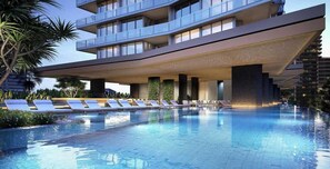 A modern hotel with a pool, sun loungers, and a multi-story structure. - The Signature Broadbeach (Broadbeach)