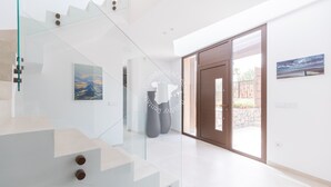 A modern interior with a glass staircase, a door leading outside, and artwork on the walls. - CostaBlancaDreams - AIR in Calpe (Calpe)