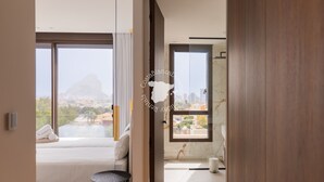 A modern hotel room with a large bed, a small round table, a bathroom with a marble sink, and a city view. - CostaBlancaDreams - AIR in Calpe (Calpe)