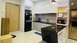 Una cocina moderna con armarios blancos, encimera negra y horno empotrado.
