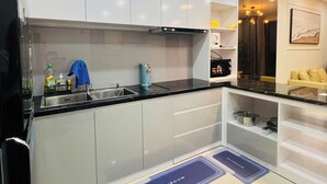 Una cocina moderna con armarios blancos, encimera negra y cocina integrada.