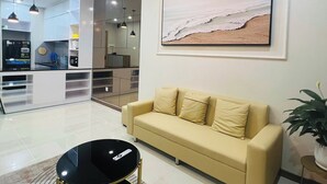 Una sala de estar moderna con un sofá, una mesa de centro y un cuadro de una playa.