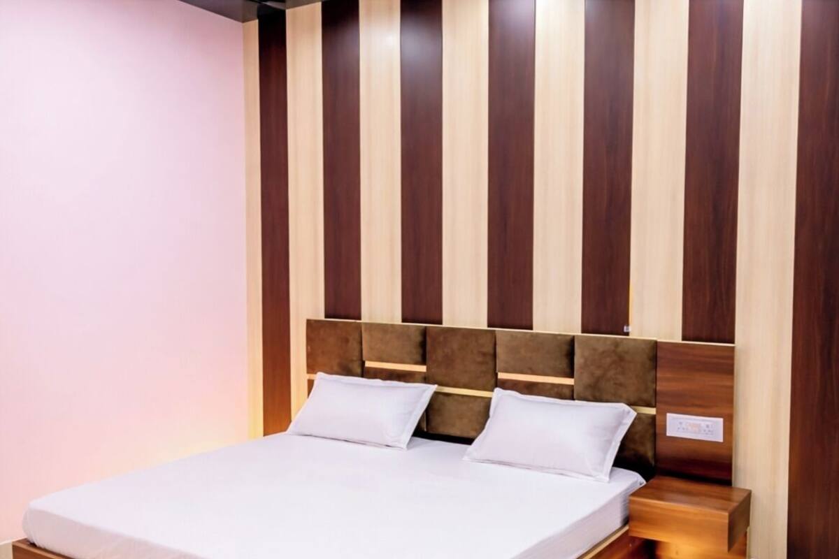 Ein modernes Bett mit Holzrahmen und einem Kopfteil aus vertikalen Holzleisten.