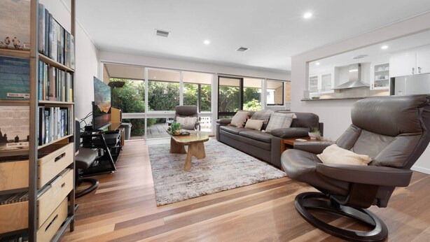 A modern living room with a sofa, armchair, and bookshelves. - Gorgeous 2-Bed Townhouse with Patio, BBQ & Parking (Kingston)