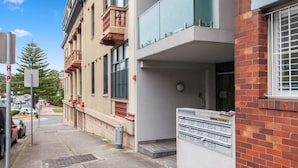 A building with a mail slot, a mailbox, and a sign with apartment numbers.