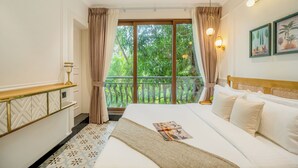 A hotel room with a large bed, a balcony with curtains, a wooden headboard, and wall-mounted lights. - Staymaster Veridian 2BR - Standard (Calangute)
