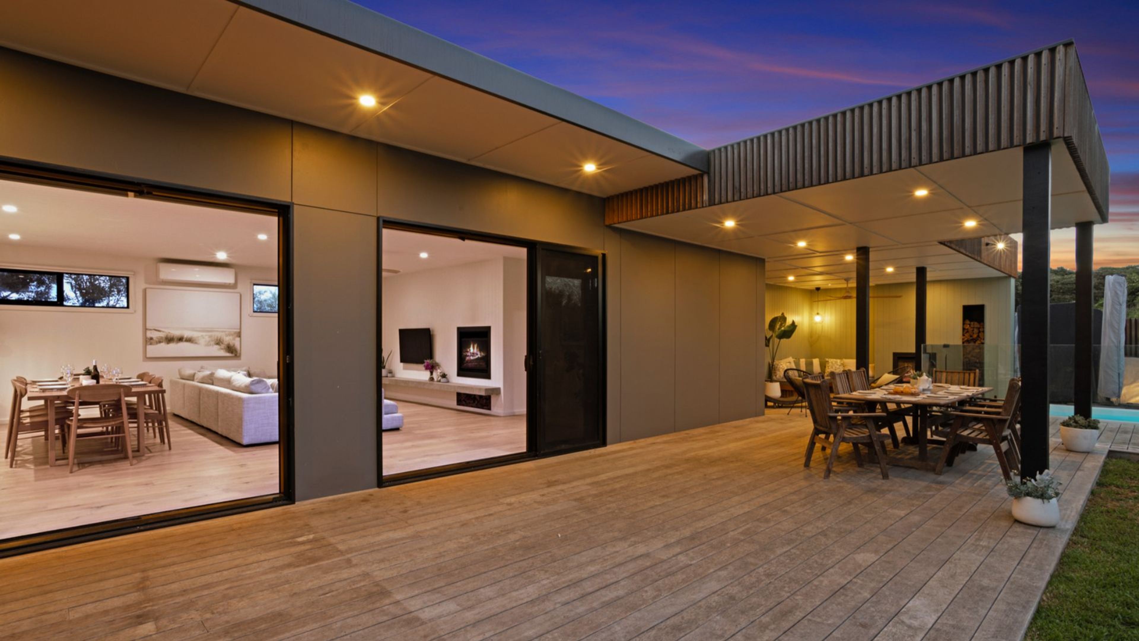 A modern house with an open-plan living area, a dining room, and a patio.