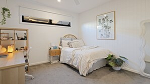 Ein Schlafzimmer mit einem Bett, einem Nachttisch, einem Schreibtisch und einem Stuhl.
