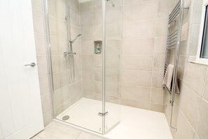 Chuveiro, secador de cabelo, toalhas de banho, papel higiênico