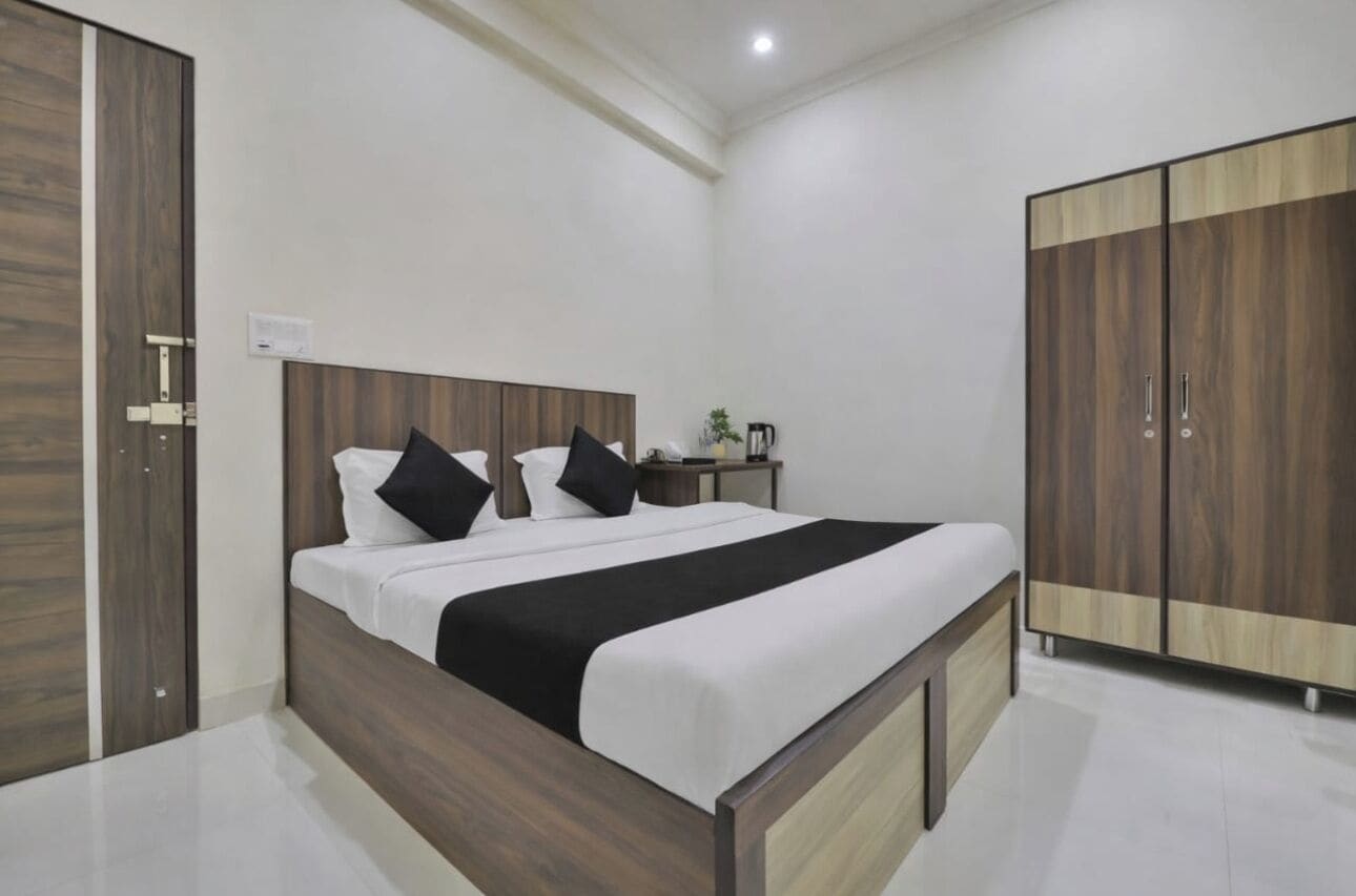 Un dormitorio moderno con estructura de cama de madera, una mesita de noche y un armario.