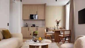 Ein modernes Wohnzimmer mit einer Couch, einem Couchtisch und einem Essbereich mit Stühlen und einem Tisch.