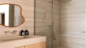 Ein modernes Badezimmer mit einer gläsernen Duschkabine, einem Holzlappen mit Waschbecken und einem Spiegel mit Holzrahmen.