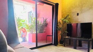 Una habitación con ventilador de techo, televisión y sofá.