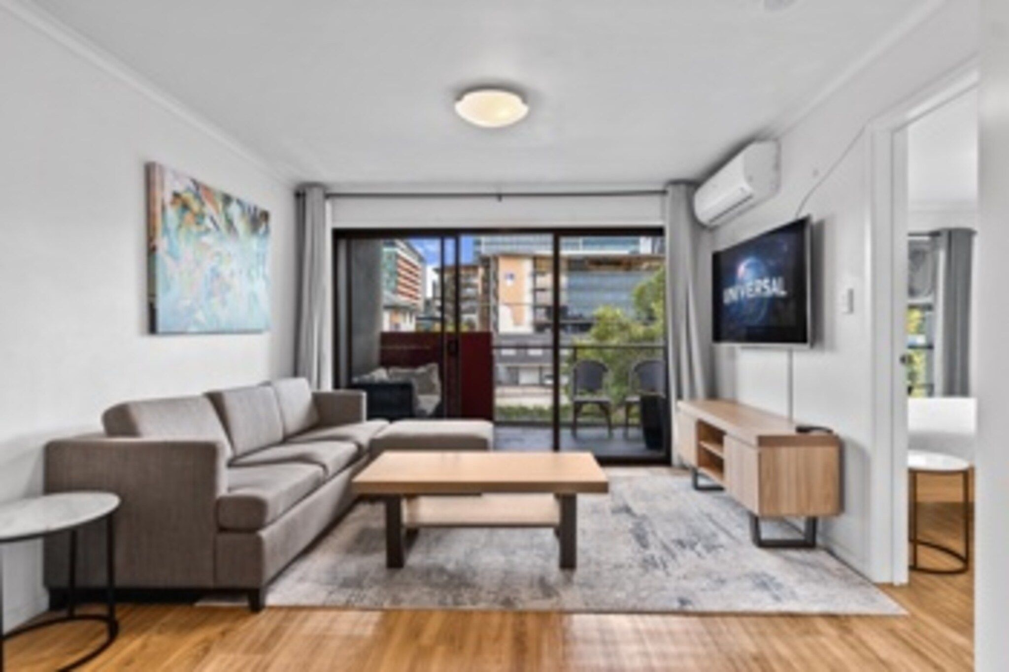 A modern living room with a sofa, coffee table, and TV.