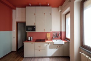 A compact kitchen with a microwave, sink, and cabinets. - The Haven Suite in Duomo (Milano)