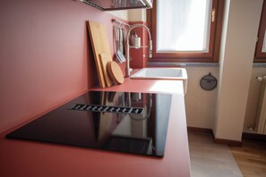 Eine moderne Küche mit schwarzer Arbeitsplatte, Schneidebrett aus Holz und einem Fenster über der Spüle.