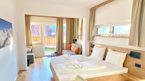 Un cuarto de hotel con una cama grande, un escritorio, una silla y vistas al exterior.