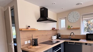 Eine moderne Küche mit Einbauherd, Mikrowelle, Spüle und einem roten Stuhl.