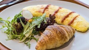A plate with an omelette, a croissant, and a salad on a wooden tray. - Atour S Hotel  Hongqiao Center Shanghai (Shanghai)