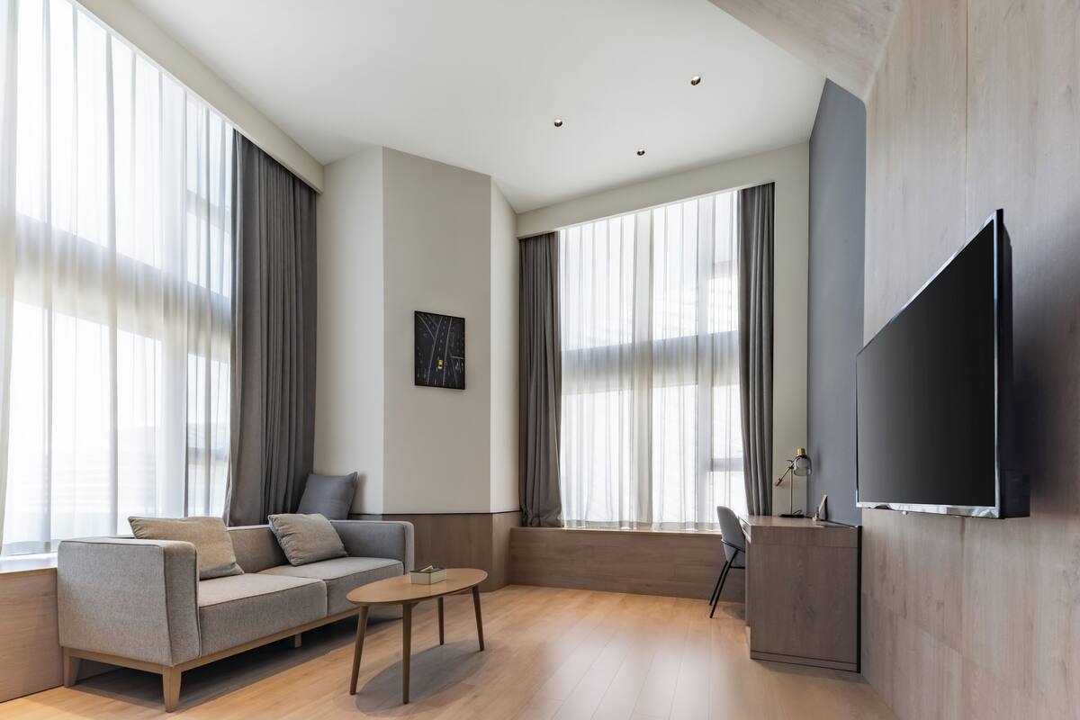 Een moderne woonkamer met een bank, salontafel en televisie.