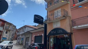 Een straatbeeld met een gebouw met de tekst 'New Line' en een bordje voor 'Outlet New Line'.
