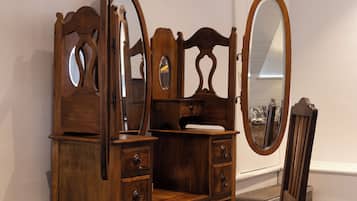 Une commode en bois avec un miroir et une chaise.