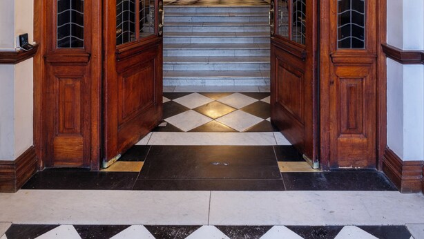 An arched wooden entrance with a checkered floor leading to a staircase. - The Cape Town Club (Cape Town)