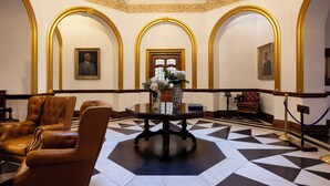 A lobby with a checkered floor, a central table with a vase, and leather chairs. - The Cape Town Club (Cape Town)