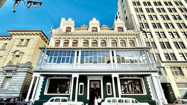 A historic building with a grand entrance, large windows, and classic cars parked in front. - The Cape Town Club (Cape Town)