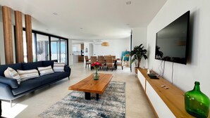 Una sala de estar moderna con sofá, mesa de centro y televisor.