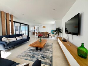 Ein modernes Wohnzimmer mit Sofa, Couchtisch und Fernseher.