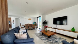 Una sala de estar moderna con sofá, mesa de centro y televisor.
