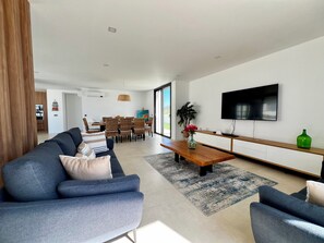 Ein modernes Wohnzimmer mit einer Couch, einem Couchtisch und einem Fernseher.