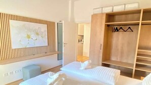 Un cuarto de hotel con una cama, un armario de madera y un cuadro en la pared.