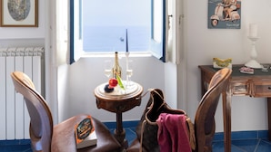 A room with a view of the sea, a table with a book and a bottle, and two chairs. - In the center of Amalfi, a dream home with a sea view! (Amalfi)