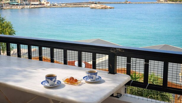 A balcony with a table, two cups, and a small dish of food. - Matroni's House - Seafront Getaway in Monemvasia (Gefira)