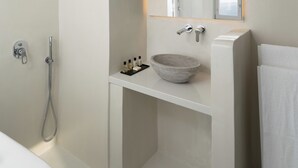 Ein modernes Badezimmer mit Dusche, Waschbecken, Spiegel und Handtuch.