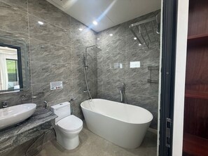 Ein modernes Badezimmer mit einer freistehenden Badewanne, einer Toilette und einem Waschbecken.