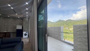 Un salon moderne doté d’une grande fenêtre, d’un lave-linge et d’un coin repas.