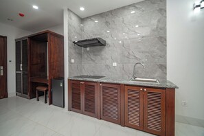 Eine Küche mit integriertem Spülbecken, Holzschränken und einer Marmor-Spritzschutzwand.