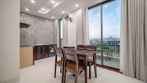 Une cuisine moderne avec un coin repas, de grandes fenêtres et une vue sur le paysage urbain.