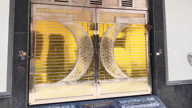 A large, ornate metal gate with intricate designs and golden accents.